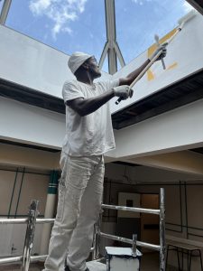 André qui peint en blanc sur ce chantier de rénovation d'école